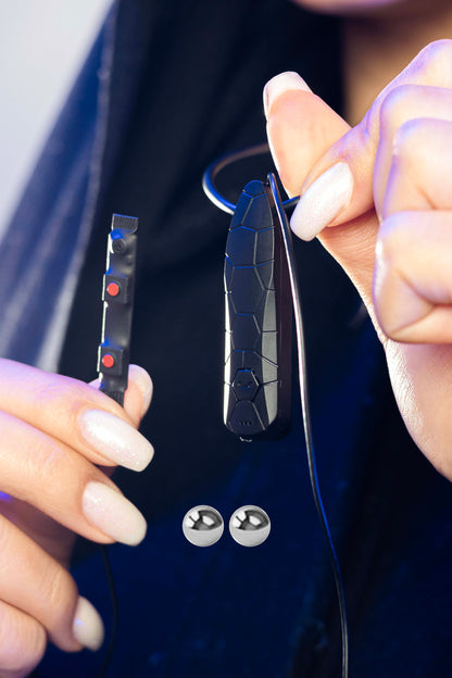 Close-up of hands showing Invisi2 Croco Plus neck unit with detachable inline mic strip and two 2 mm bead receivers